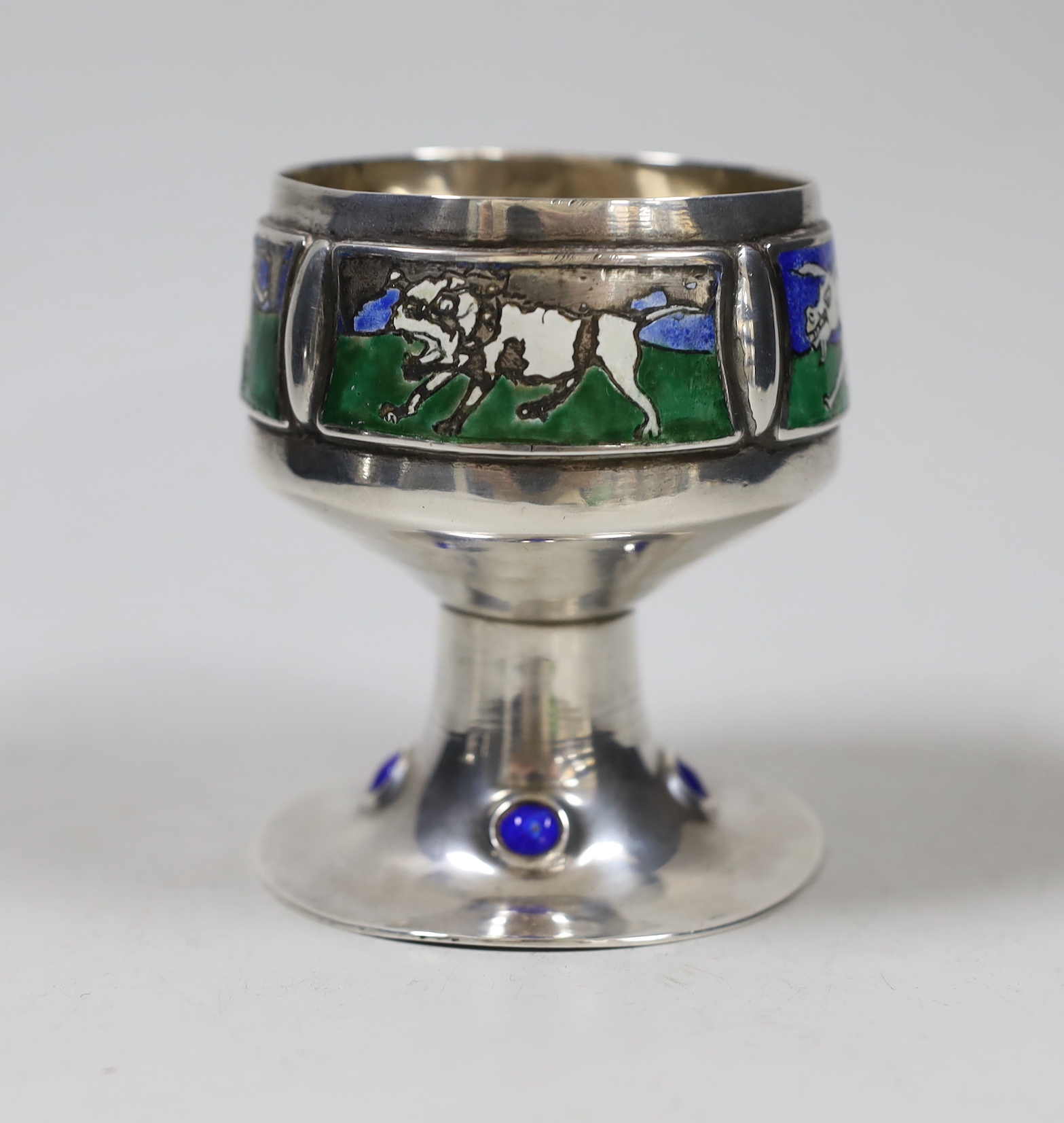 An Edwardian Arts and Crafts silver and enamel chalice, overstamped maker's mark, London, 1902, height 9.3cm, decorated with animals, on a beaded foot, gross 9.6oz.